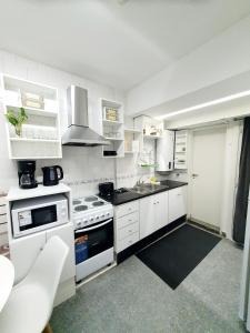a kitchen with white appliances and white cabinets at Obelisco Deptos in Buenos Aires
