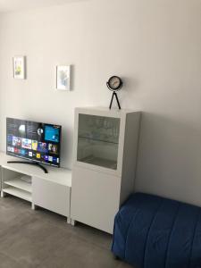 een slaapkamer met een bed, een tv en een bureau bij Mar Jonica 1 in Denia