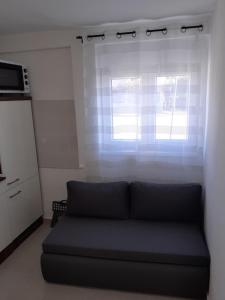 kanapę w salonie z oknem w obiekcie Studio apartman LORENA w mieście Zadar