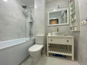 a white bathroom with a toilet and a sink at Best apartments on Lyatoshinsky street in Zhytomyr
