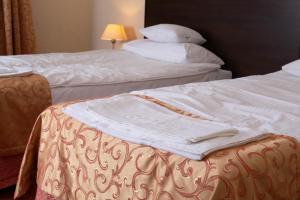 two beds in a hotel room with white sheets and pillows at Neptun in Legnica +8 photos