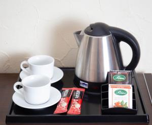 a tray with a coffee maker and cups on a table at Neptun in Legnica