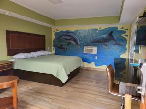 a bedroom with a mural of a fish on the wall at Travel Inn of Riviera Beach in Riviera Beach