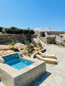 a swimming pool in a yard with some chairs at Apostolis House in Mikonos