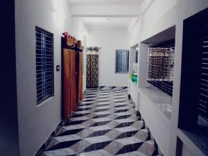 a hallway with a black and white tiled floor at Sundarban Tulip Homestay, Pakhiralay, WB in Purbbadulki