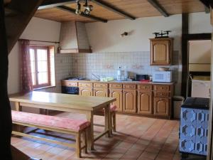 cocina con armarios de madera y mesa de madera en Gîte la Ferme, en Mutzig