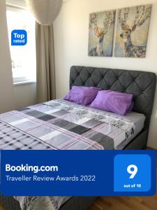 ein Schlafzimmer mit einem Bett mit lila Kissen in der Unterkunft Artemis Apartment - nice, family friendly and cozy in Skopje