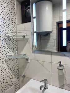 Baño blanco con lavabo y espejo en Vanilla Ice apartment en Varna