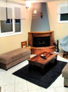 a living room with a couch and a fireplace at POLYTIMI HOUSE in Kalavrita