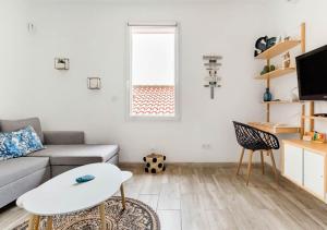 ein Wohnzimmer mit einem Sofa und einem Tisch in der Unterkunft Studio contemporain + Terrasse - Port de l'Estaque in Marseille