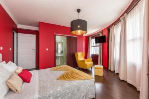 a red bedroom with a bed and a yellow chair at Oporto Santa Catarina Residence in Porto