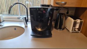 a black coffee maker sitting on top of a counter at Kasekese Holiday Home with Sauna and Garden in Kuressaare