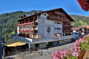 a building with tables and chairs in front of it at Familienhotel Post in Serfaus