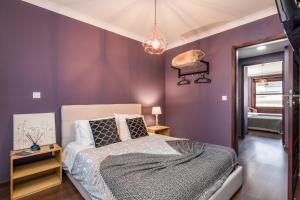 una camera da letto con pareti viola e un letto interno di Oporto Santa Catarina Residence a Porto