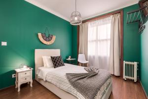 ポルトにあるOporto Santa Catarina Residenceの緑の壁、ベッド付きのベッドルーム1室