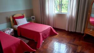a bedroom with two beds and a mirror and a window at Hospedaria Rofamos in Conselheiro Lafaiete +18 photos