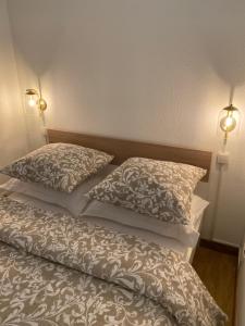 a bed with two pillows on top of it at Vue sur l’eau in Cap d'Agde