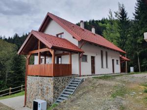 ein kleines weißes Haus mit rotem Dach in der Unterkunft Apartma Ribnica na Pohorju in Ribnica na Pohorju