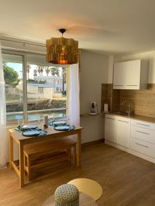 a kitchen with a wooden table and a window at Vue sur l’eau in Cap d'Agde