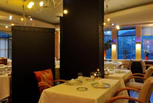 a dining room with white tables and chairs at Le Haut Allier in Alleyras