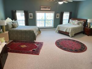 a bedroom with two beds and a rug at Full Circle Farm Inn in Franklin