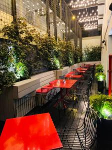 uma fila de mesas vermelhas num restaurante com plantas em Radisson RED Miraflores em Lima