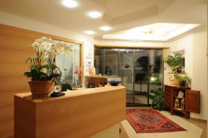 um quarto com um balcão com um vaso de flores em Hotel FleurAlp em Cermes