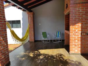 2 chaises assises dans une pièce avec un mur en briques dans l'établissement Sueño Luqueño, à Luque