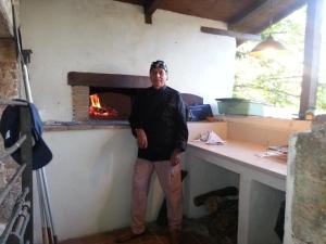 a man standing in front of a brick oven at Casale Druida in Poggio Mirteto