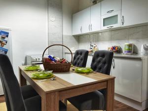 a kitchen with a wooden table with chairs and a counter at Pale city center apartment in Pale