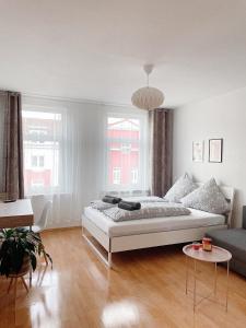 a white bedroom with a bed and a couch at Modern & cozy Rooms Leipzig-Gohlis in Leipzig