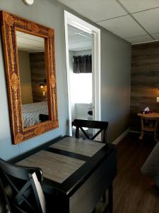 een kamer met een spiegel, een tafel en een bed bij Motel Shantik in Montebello