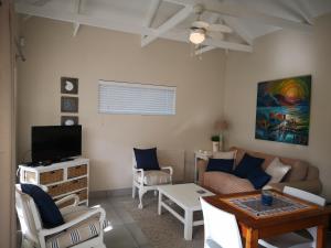 赫曼努斯Seashell Cottage的客厅里有一张沙发和一张桌子。