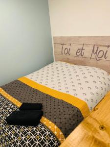 a bed with a comforter and a sign that says not at Appartement cocooning pour un séjours à Tende in Tende