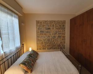 a bed in a bedroom with a brick wall at Residenza Azzurra in Cattolica