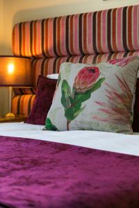 a bed with a pillow with a flower on it at Entire 5 Bedroom 5 Bathroom Sea Point Villa with Secure Parking in Cape Town