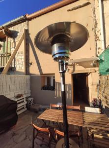 eine Straßenbeleuchtung mit einem Tisch und Stühlen auf einer Terrasse in der Unterkunft Cerverahouse in Cervera de Buitrago
