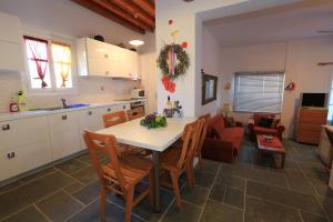 Una cocina y un comedor con mesa y sillas. en Villa Perivoli, en Platis Yialos Sifnos