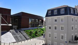 un grand bâtiment à côté d'un bâtiment avec un escalier dans l'établissement Hôtel Oxo, à Biarritz