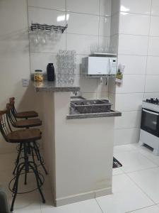 a kitchen with a stove and a counter with stools at Nesga Village in Lençóis
