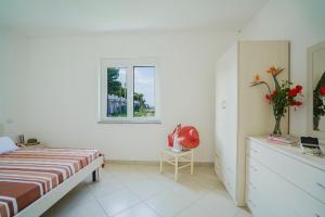 um quarto com uma cama, uma cómoda e uma janela em VILLAGGIO RESIDENCE EMMESSE em Zambrone