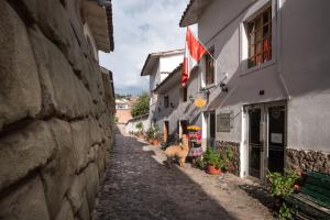 un callejón con dos ovejas de pie junto a un edificio en Hotel Monasterio del Inka, en Cusco