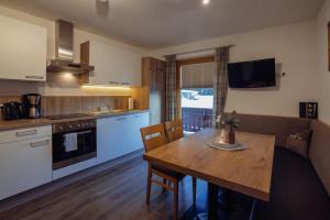 a kitchen and dining room with a table and a couch at Beim Kathrein - inklusive SILVRETTA Card Premium in Galtür