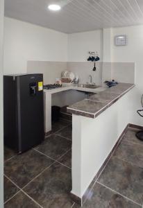 a kitchen with a black refrigerator and a sink at Hermoso apartamento con servicios y garaje. in Florencia