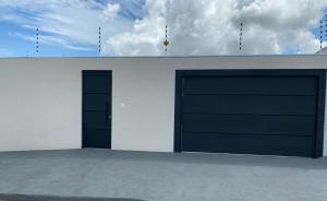 zwei Garagentüren in einem weißen Gebäude mit einem Himmel in der Unterkunft Casa De Temporada Eldorado 2 in Olímpia
