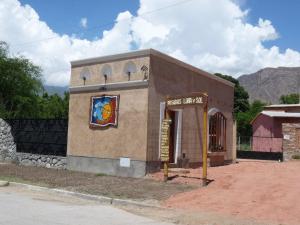un petit bâtiment avec un panneau sur son côté dans l'établissement Cabañas Luna y Sol, à Cafayate
