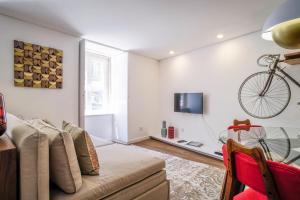 a living room with a couch and a bike hanging on the wall at Casa 36 Exquisite Flat in Lisbon