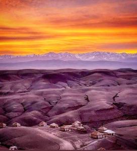 uma pintura de um deserto com montanhas ao fundo em Agafay Luxury camp em Marraquexe