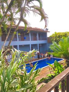 a resort with a swimming pool next to a building at Pousada Olhar da Sereia in Arraial d'Ajuda