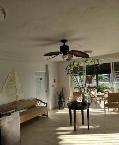 a living room with a couch and a ceiling fan at Hotel Caracoles Colima in Colima